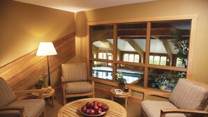A cozy room with a large window, a wooden ceiling, and a round wooden table with apples. - von Trapp Family Lodge & Resort (Stowe)