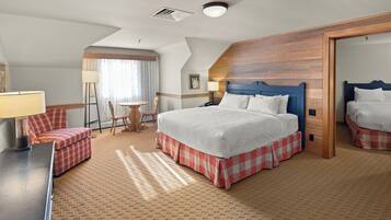 A hotel room with a large bed, a desk, a chair, and a small table.