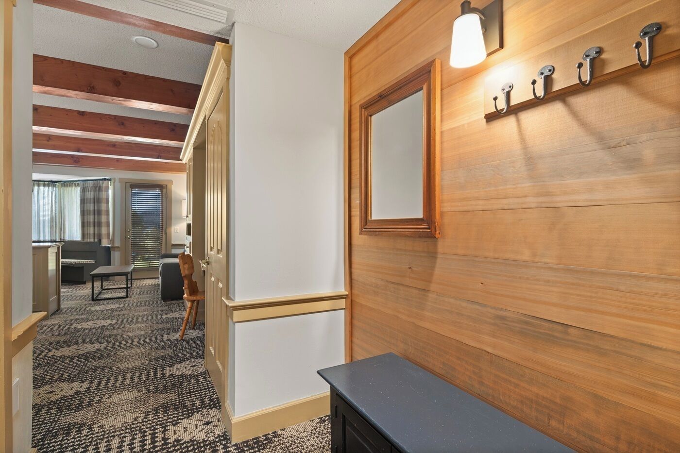 Een hotel lobby met een houten wand, een spiegel en een lamp.