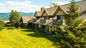 A large, multi-story building with a sloped roof, surrounded by a well-maintained lawn and trees. - von Trapp Family Lodge & Resort (Stowe)