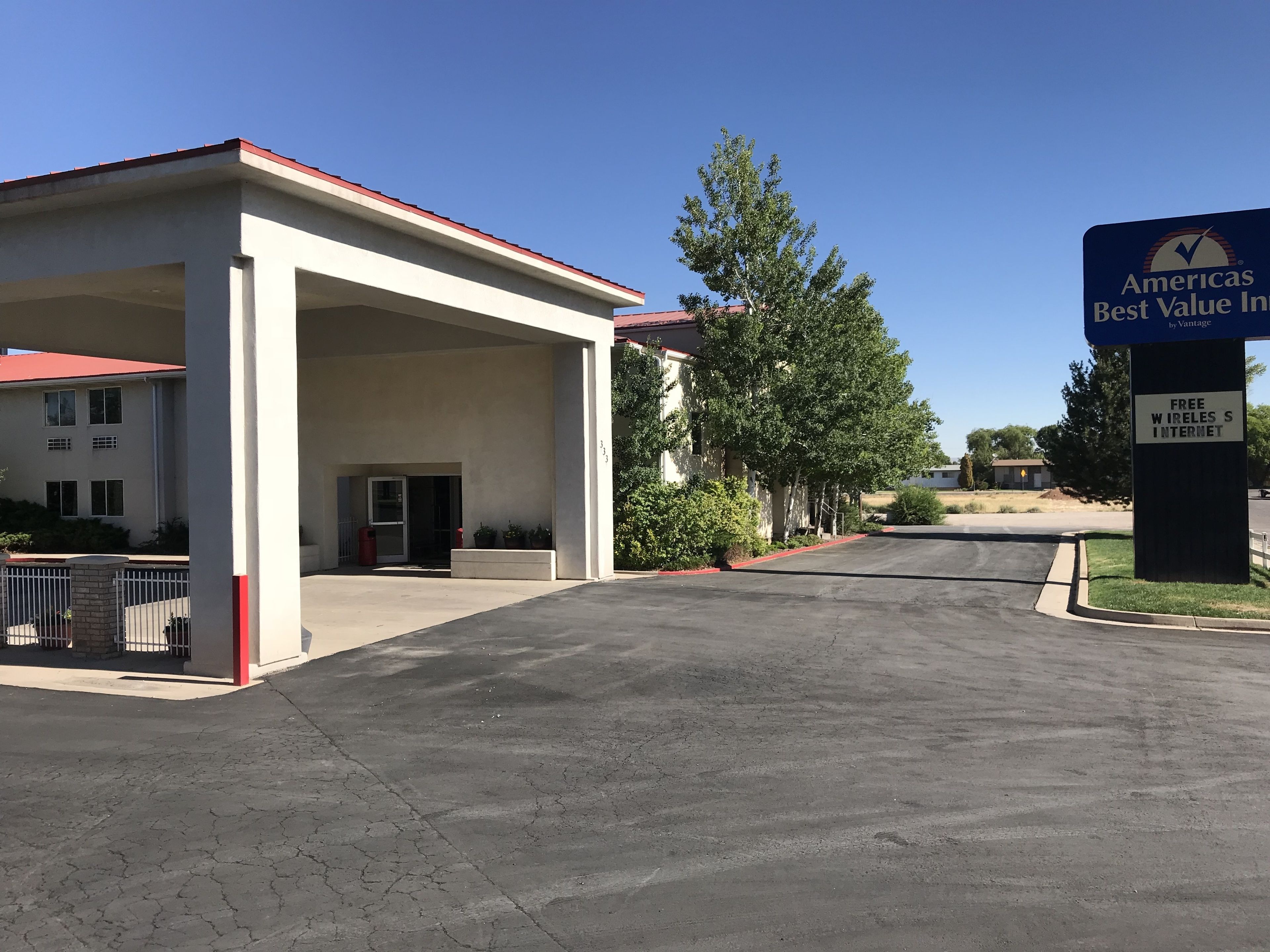 A building with a covered entrance, a sign indicating free wireless internet, and a clear sky.