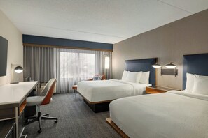 A hotel room with two beds, a desk, a chair, and a large window with curtains. - Courtyard by Marriott Kokomo (Kokomo)