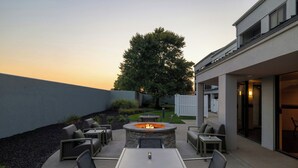 An outdoor patio area with a fire pit, seating, and a view of the backyard. - Courtyard by Marriott Kokomo (Kokomo)