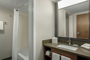 A modern bathroom with a shower, a sink, and a mirror. - Courtyard by Marriott Kokomo (Kokomo)