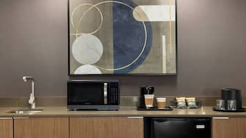 A modern kitchen with a built-in microwave, coffee maker, and dishwasher.