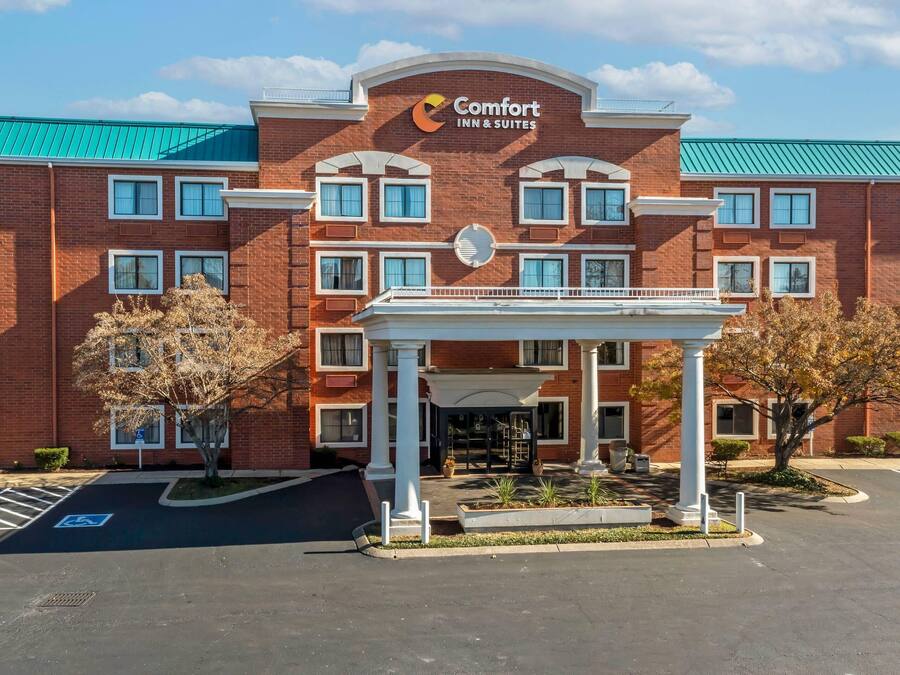 Um hotel Comfort Inn & Suites com fachada de tijolos, várias janelas e entrada coberta.