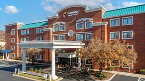 A brick building with a sign for Comfort Inn & Suites, a covered entrance, and a parking lot with handicapped parking. - Comfort Inn & Suites Brentwood - Nashville (Brentwood)