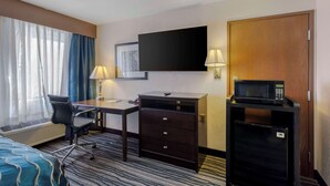 A hotel room with a desk, chair, TV, minibar, and a bed. - Comfort Inn & Suites Brentwood - Nashville (Brentwood)