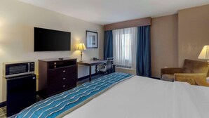 A hotel room with a bed, a desk, a chair, a television, and a microwave. - Comfort Inn & Suites Brentwood - Nashville (Brentwood)