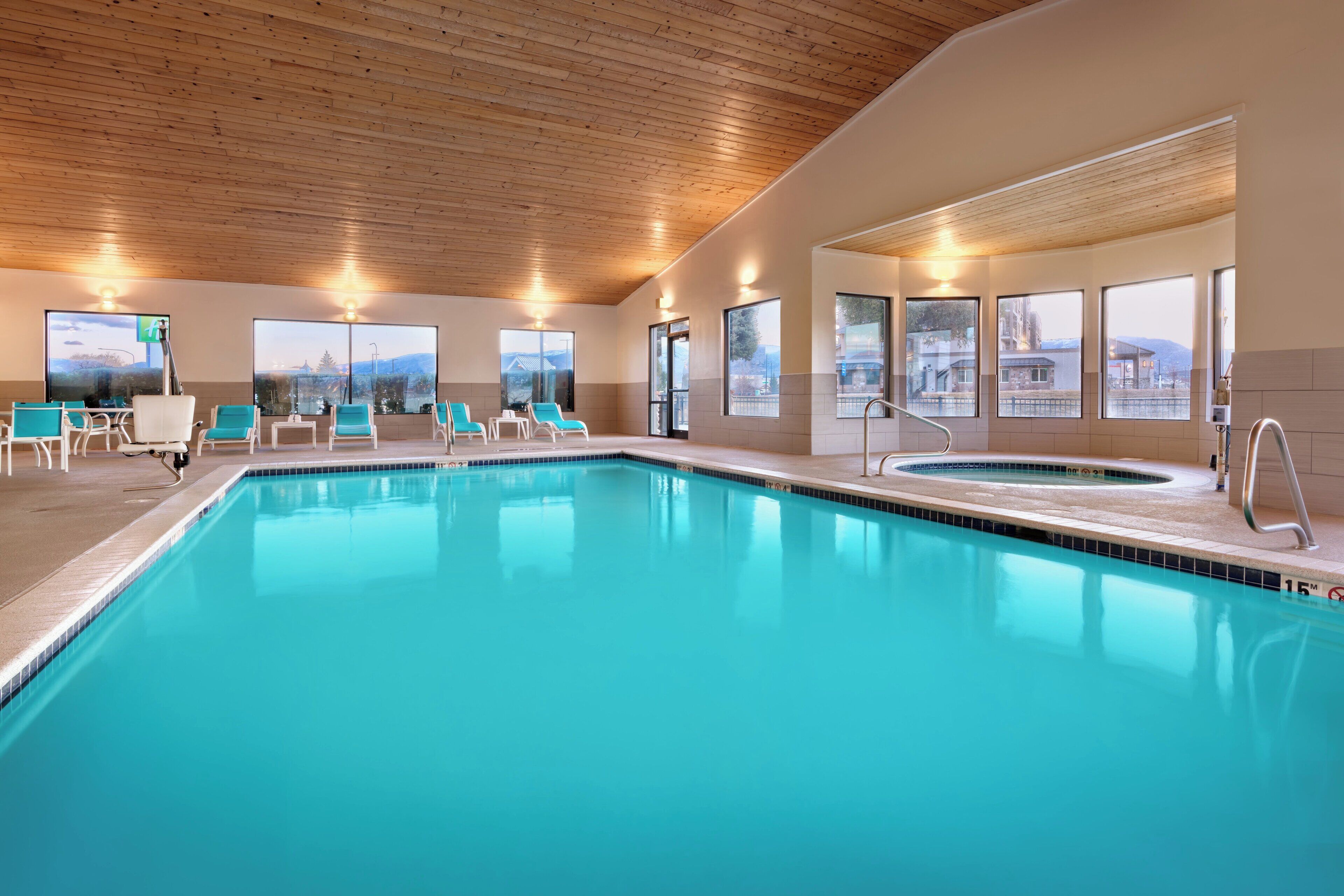A swimming pool with lounge chairs and a view of the cityscape.