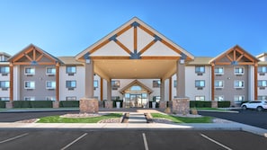 A multi-story hotel with a central entrance, outdoor parking, and a landscaped area with stone pillars. - Holiday Inn Express Heber City by IHG (Heber City)