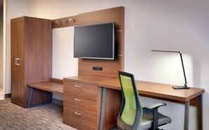 A modern office space with a wooden desk, a chair, a TV mounted on the wall, and a desk lamp. - Holiday Inn Express Heber City by IHG (Heber City)