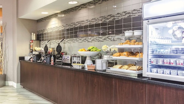 Una barra de desayuno con una variedad de alimentos, como frutas, pasteles y productos lácteos.