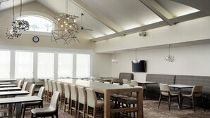 A conference room with a long table, chairs, a sofa, and a TV on the wall. - Residence Inn By Marriott Las Vegas/Green Valley (Henderson)