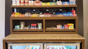 En snackbod med forskelligt chips og snacks, samt to kølede drikkemaskiner.
