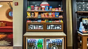 Una exhibición de bocadillos con papas fritas y un refrigerador de bebidas.