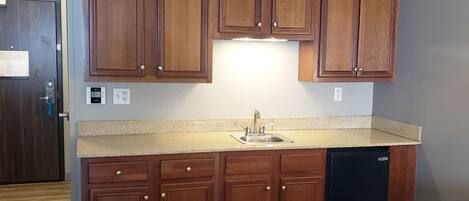 A kitchen with wooden cabinets, a stainless steel sink, and a dishwasher.
