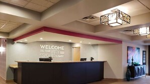 Un área de recepción con un cartel que dice 'Welcome to the Key Stone State', un mostrador de recepción y una lámpara de araña moderna.