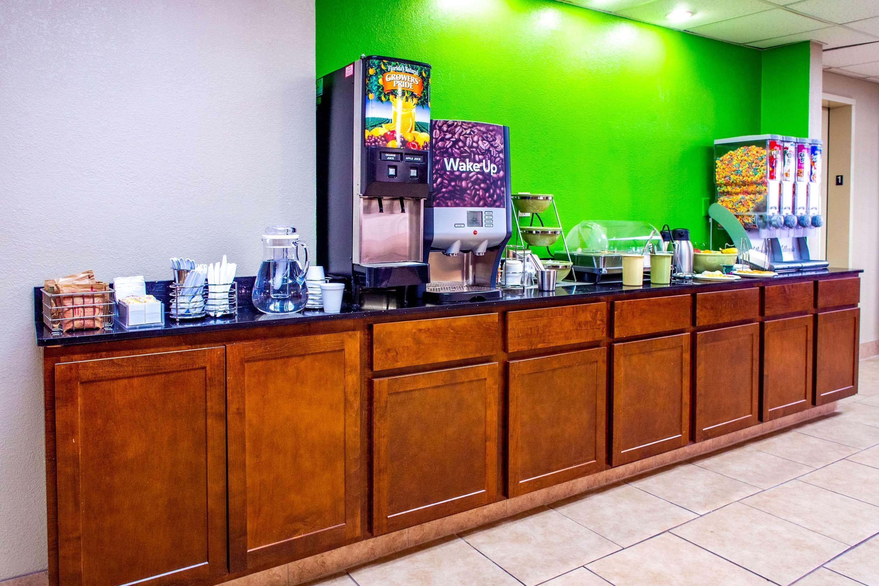A breakfast bar with coffee machines, a juice dispenser, and a cereal dispenser.