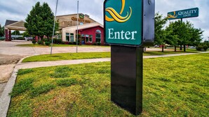 A Quality Inn sign with a green background and yellow and white lettering.