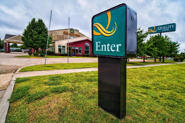A Quality Inn sign with a green background and yellow and white lettering.