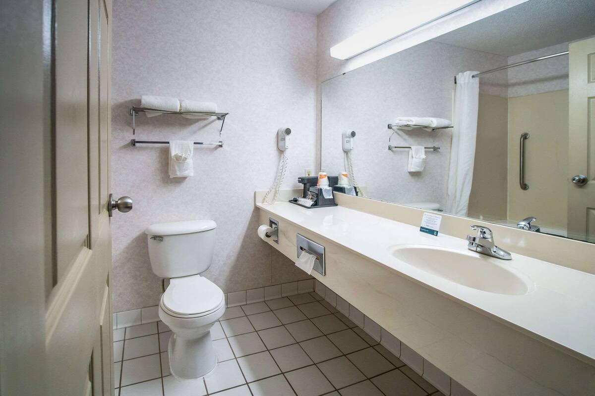 A modern bathroom with a toilet, sink, and mirror.