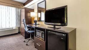 A hotel room with a desk, a television, a microwave, a refrigerator, a chair, and a window with curtains. - Sleep Inn Matthews - Charlotte (Matthews)