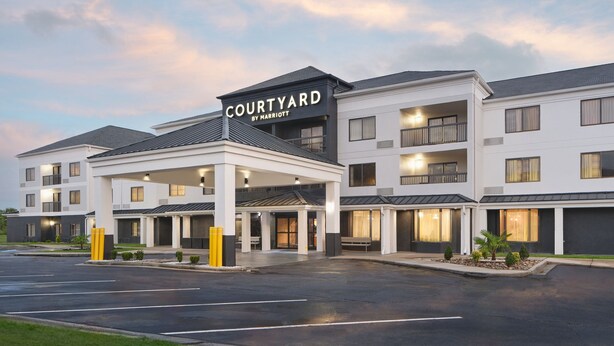 A Courtyard by Marriott hotel with a covered entrance, multiple floors, and a parking lot. - Courtyard by Marriott Florence (Florence)