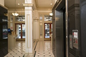 A hotel lobby with a check-in counter, a reception desk, and a sign for the 'Squire Hotel.' - Union Square Plaza Hotel (San Francisco)