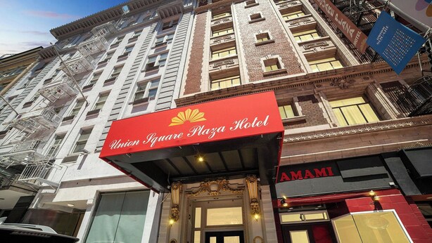 A hotel entrance with a red awning, a large glass door, and a sign for the Hotel Squared Plaza Hotel. - Union Square Plaza Hotel (San Francisco)