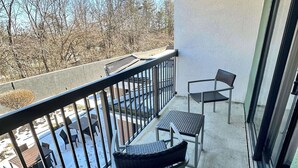 A balcony with a view of a snowy landscape and bare trees.