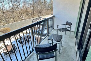 A balcony with a view of a snowy landscape and bare trees.