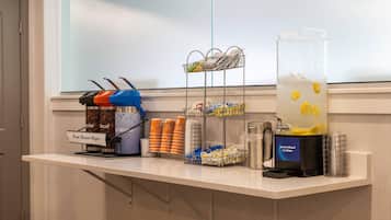 Estación autoservicio de bebidas con café, té y agua saborizada al limón.