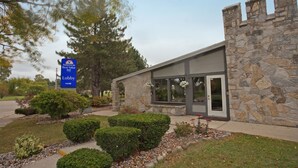 A stone building with a modern entrance and a sign indicating an American Best Value Inn lobby. - Americas Best Value Inn Lansing (Lansing)