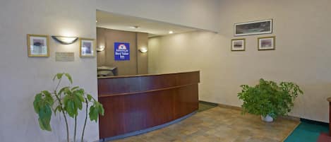 Un área de recepción con un mostrador de madera, una planta en maceta y un cartel que indica que es un Best Value Inn.