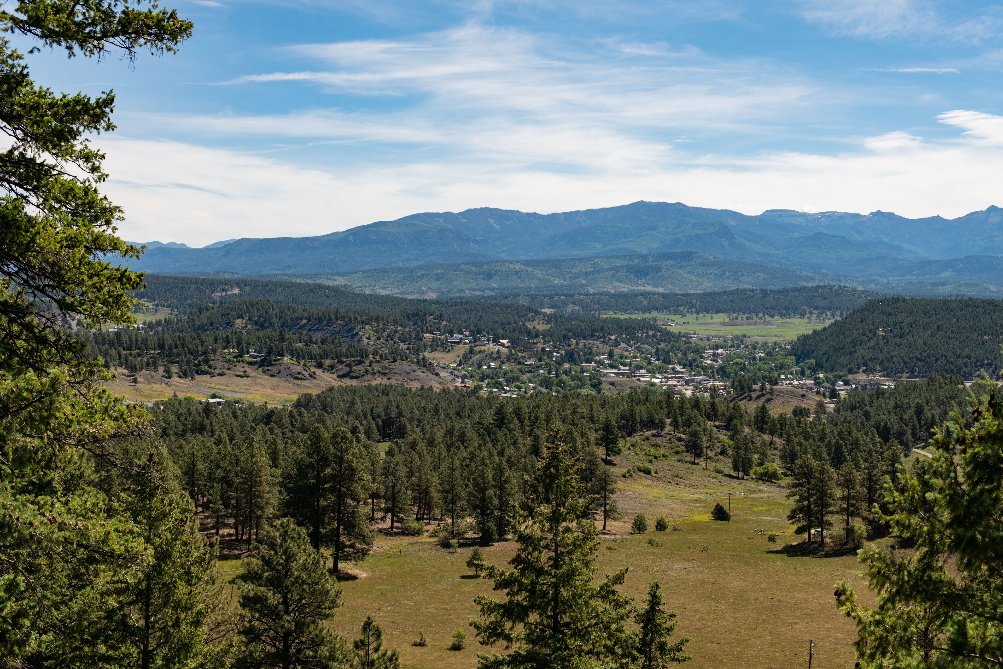 Eine gebirgige Landschaft mit dichten Wäldern und einer kleinen Stadt im Tal.