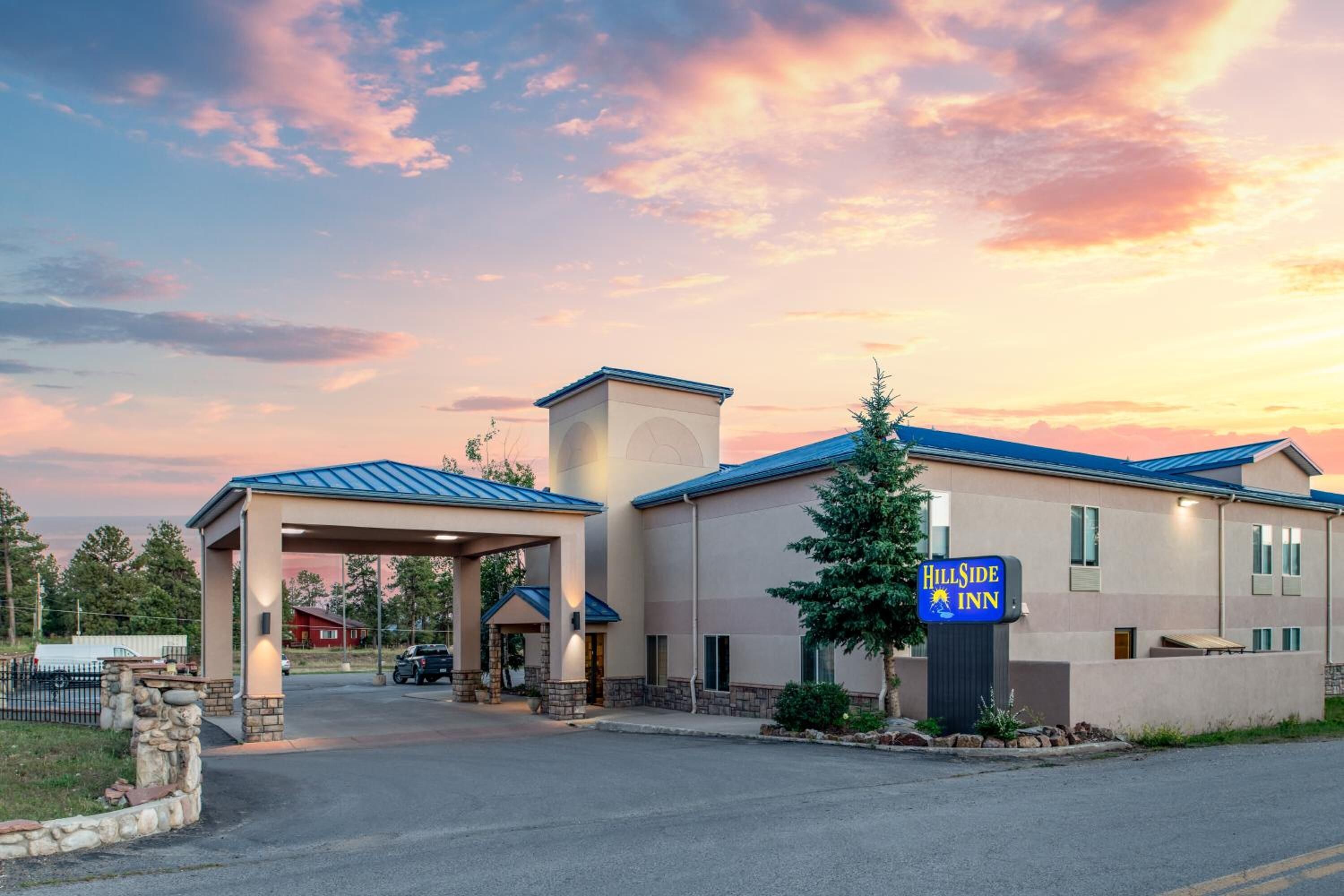 A Hillside Inn building with a covered entrance, a sign, and a parking lot.