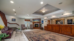 A spacious lobby with a fireplace, comfortable seating, and a large rug.