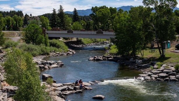 A river with rocks and a bridge in the background.