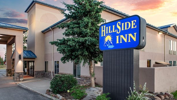 A HillSide Inn with a prominent sign, a well-maintained exterior, and a landscaped entrance area.