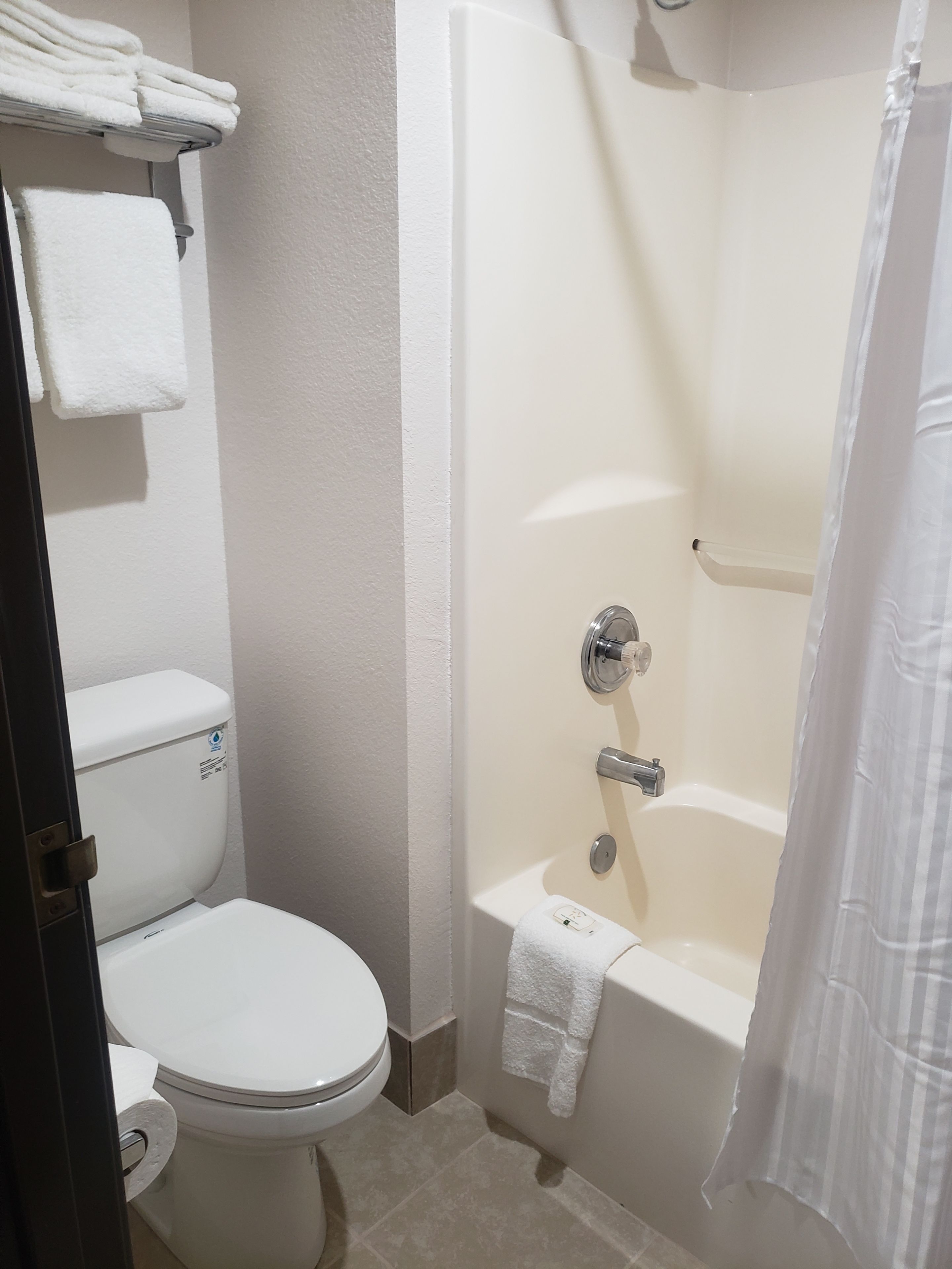 Un baño con inodoro, bañera y cortina de ducha.