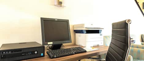 Un escritorio con una computadora HP ProDesk, un monitor, un teclado e impresora.