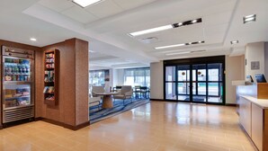 Un hall d’entrée spacieux avec un distributeur automatique, un espace détente et un comptoir d’accueil.
