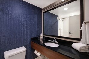 A bathroom with a black countertop, white sink, and a large mirror. - Fairfield Inn & Suites by Marriott Rochester West/Greece (Rochester)