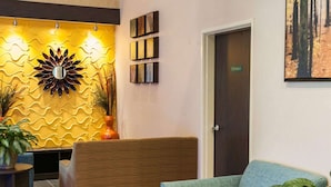A lobby with a reception desk, a blue sofa, and a door marked "STAIRWAY".