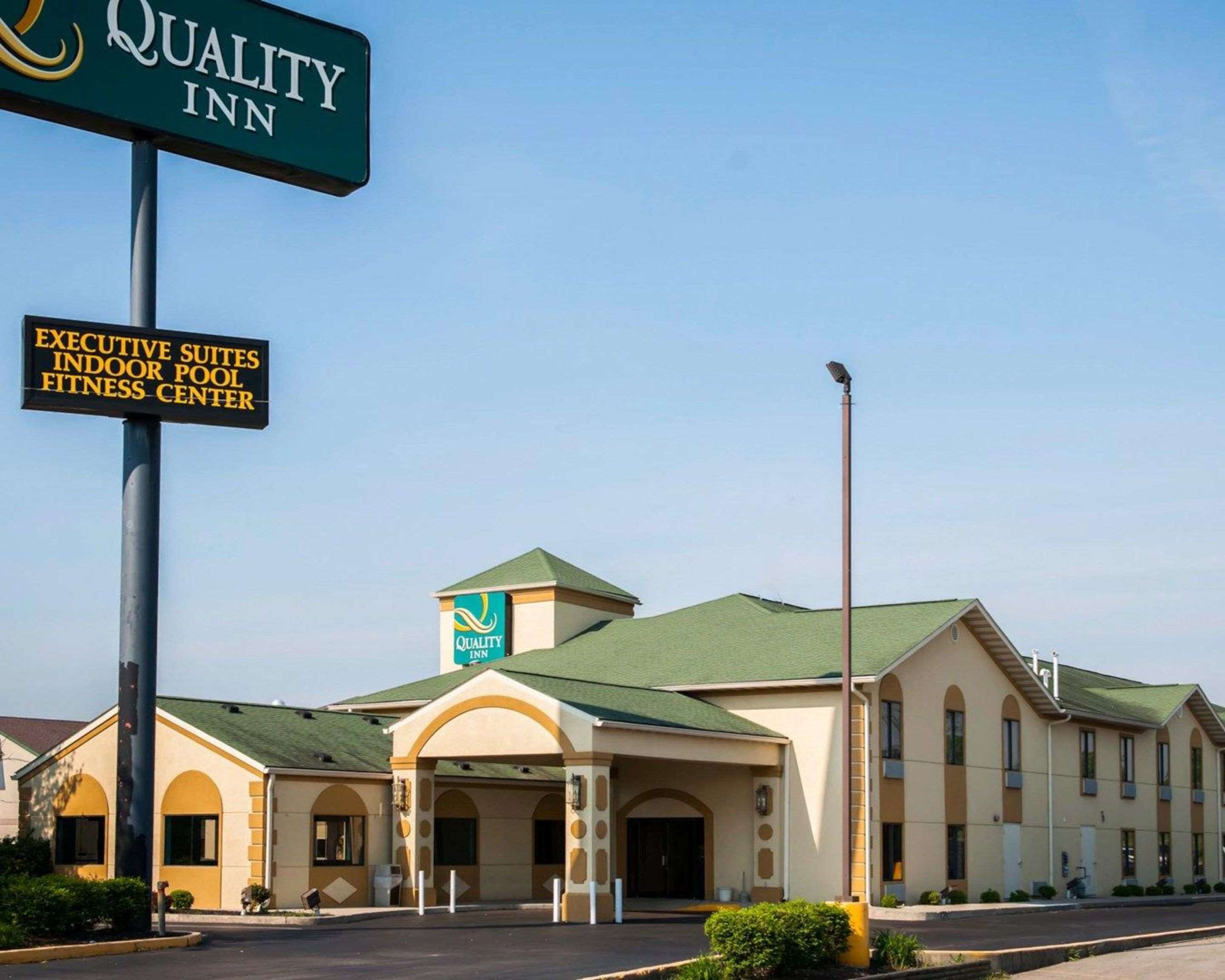 Un hotel Quality Inn con un cartel que indica suites ejecutivas, piscina cubierta y gimnasio.