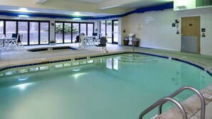 An indoor swimming pool with clear water, a tiled deck, and a few lounge chairs. - Hampton Inn Glenwood Springs (Glenwood Springs)