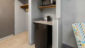 A compact kitchenette with a microwave, coffee maker, and a dishwasher.