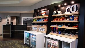 A snack bar with shelves stocked with various snacks and a refrigerator. - Hampton Inn Glenwood Springs (Glenwood Springs)