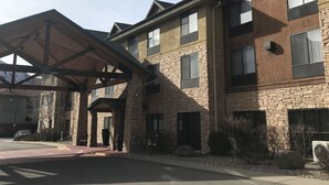 Edificio de Hampton Inn con fachada de piedra, múltiples ventanas y un área de entrada cubierta.